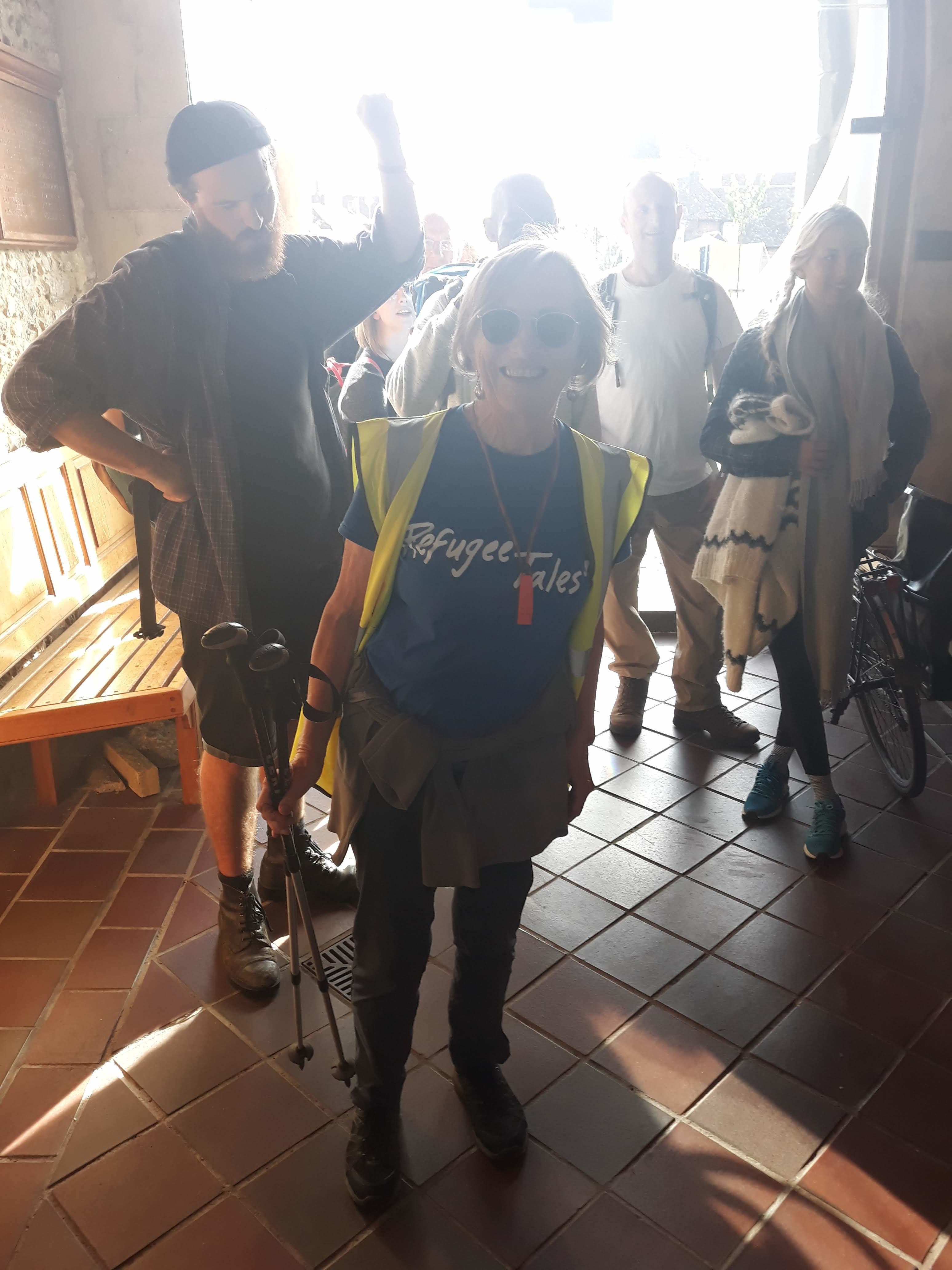Group of walkers, inside church, just as they've finished walking.