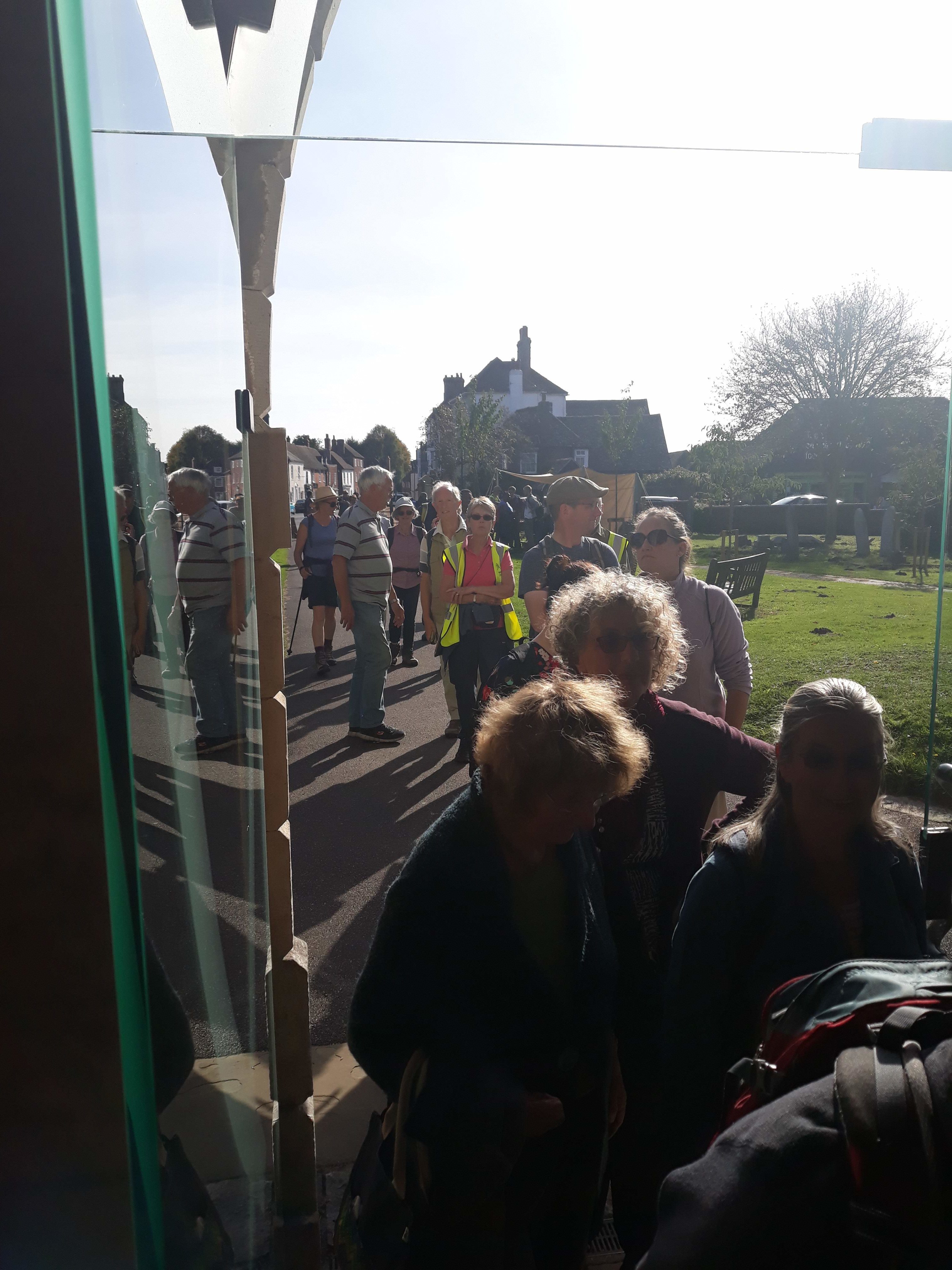 Group of walkers, on path walking into church grounds.