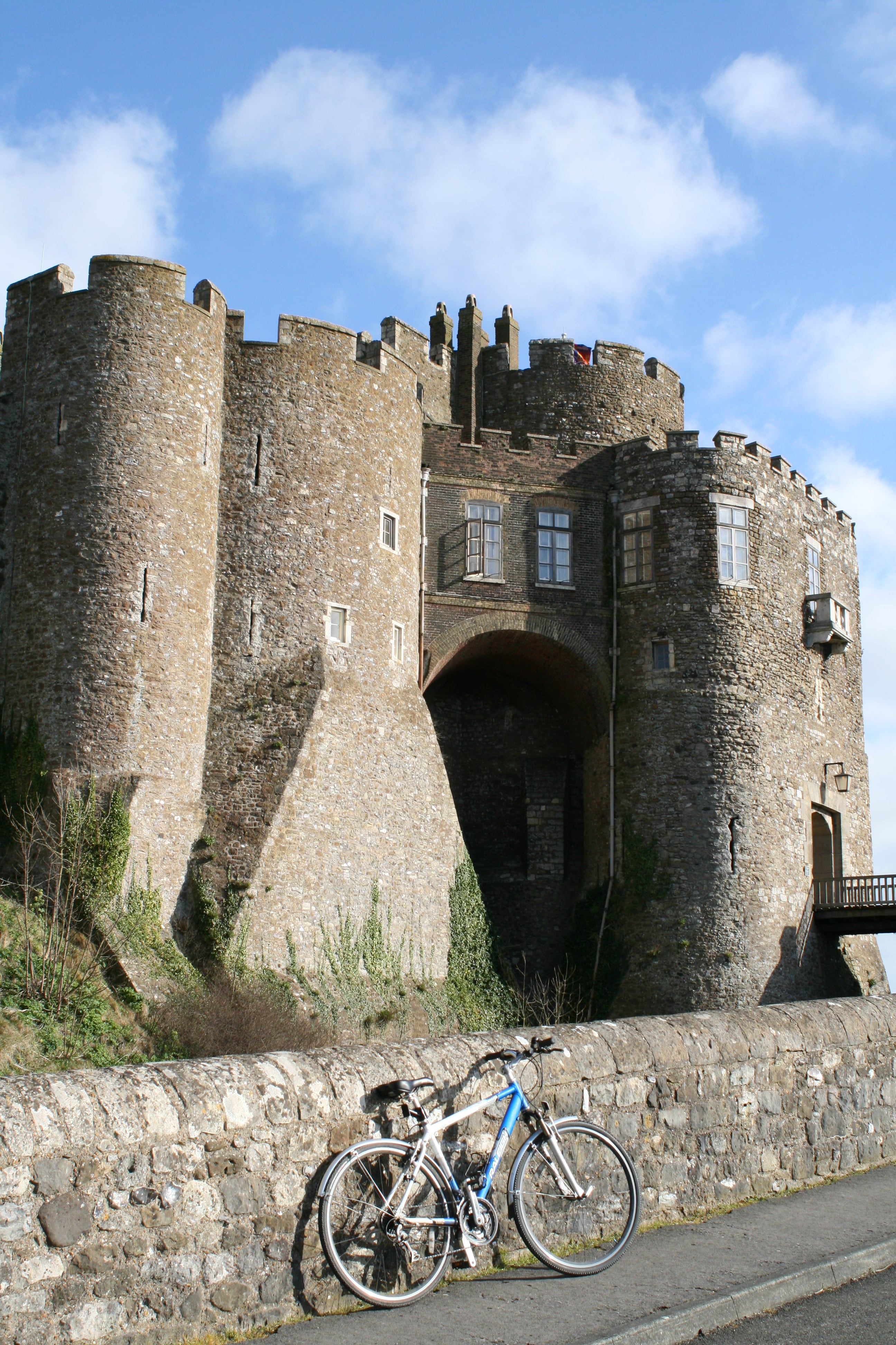 Bike leaning against stone wall, with Dover Castle in background on a sunny day. Credit David Young-Sustrans.