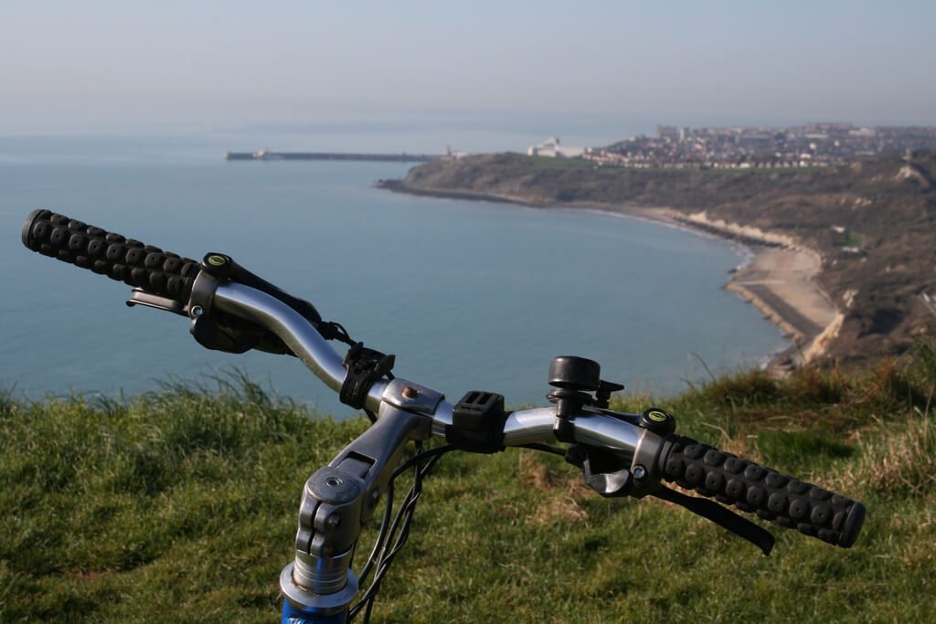 Bike handlebars overlooking beach and Port of Dover, on a sunny day.