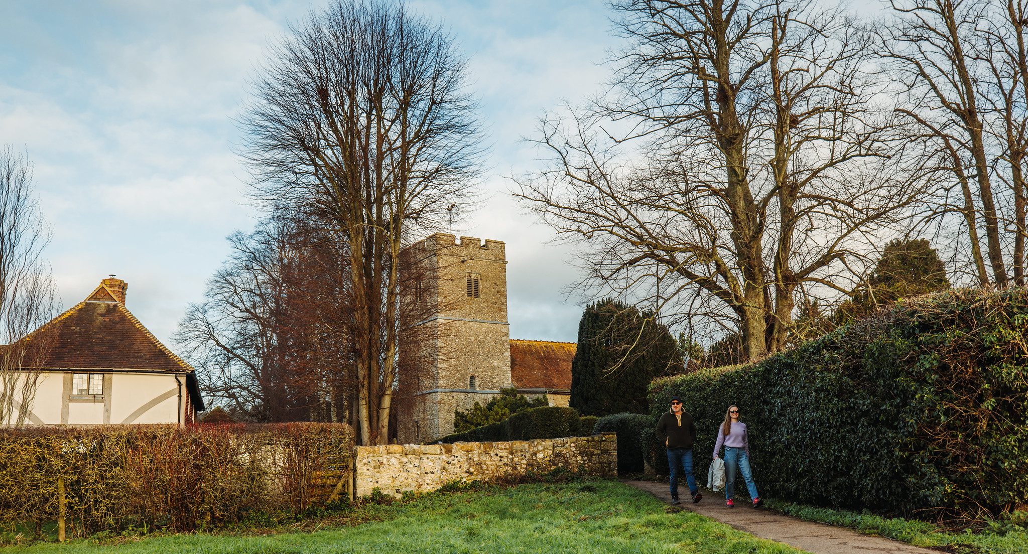 Couple walking through village with church behind