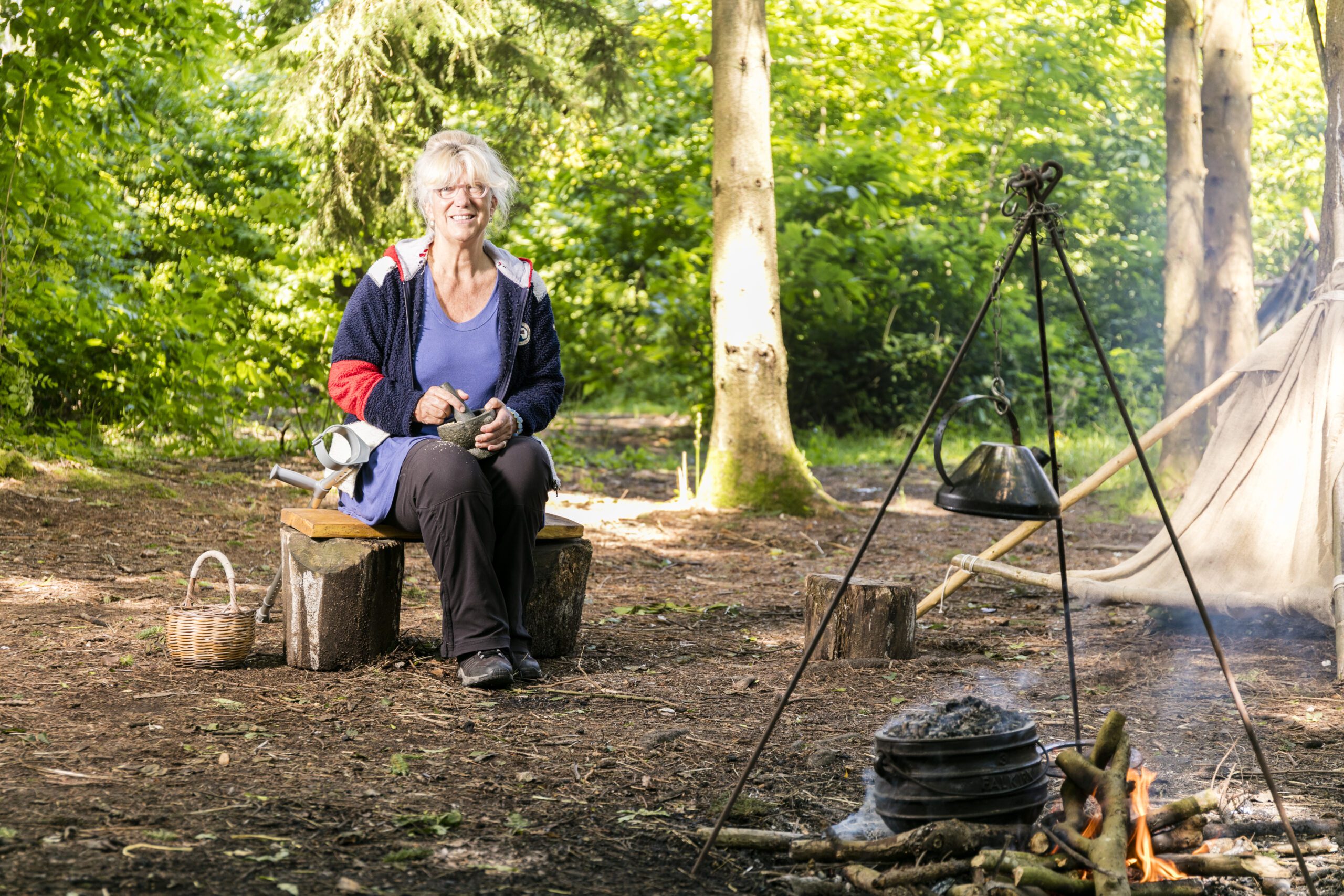 Smiling woman posing by campfire