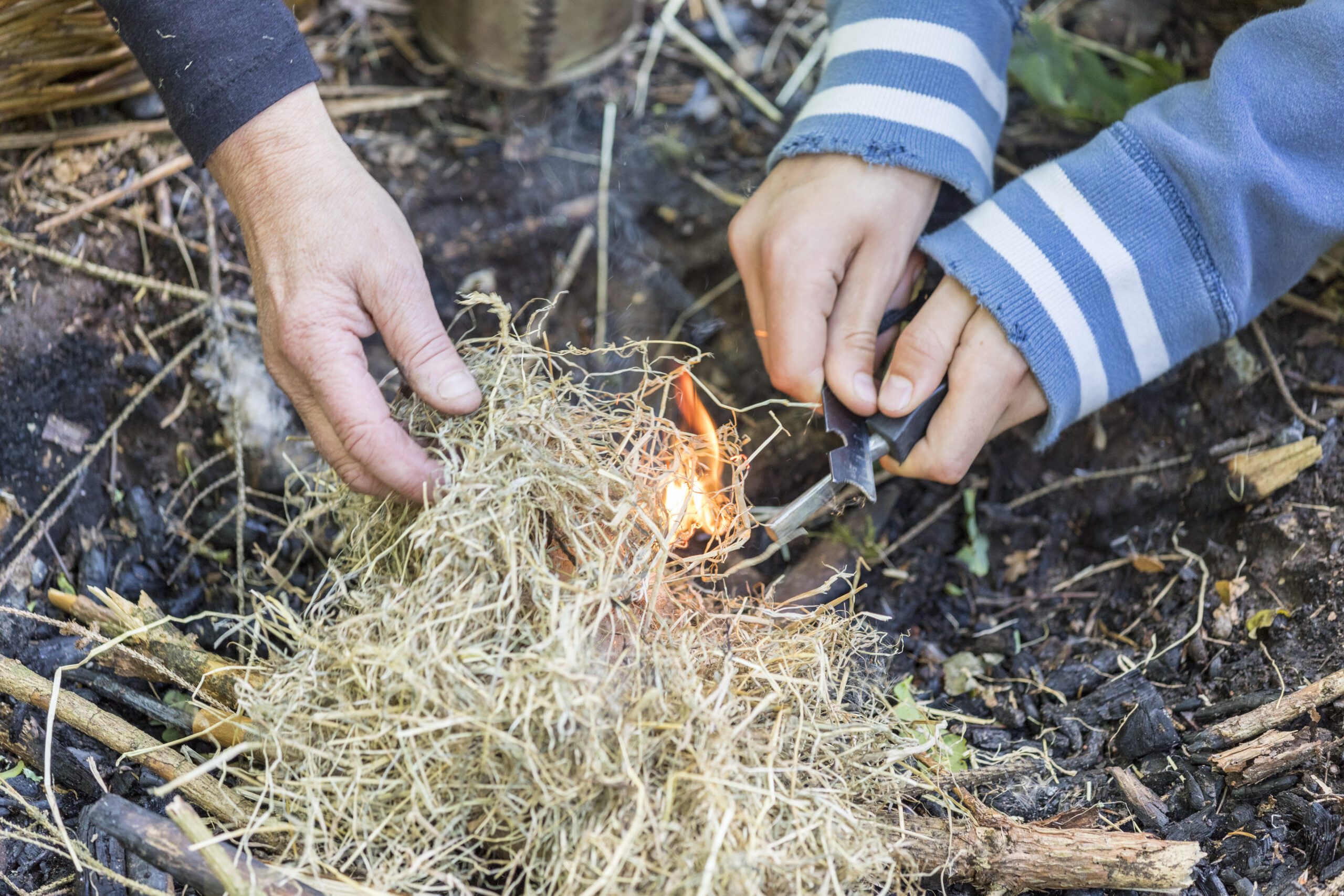 Hands lighting the campfire