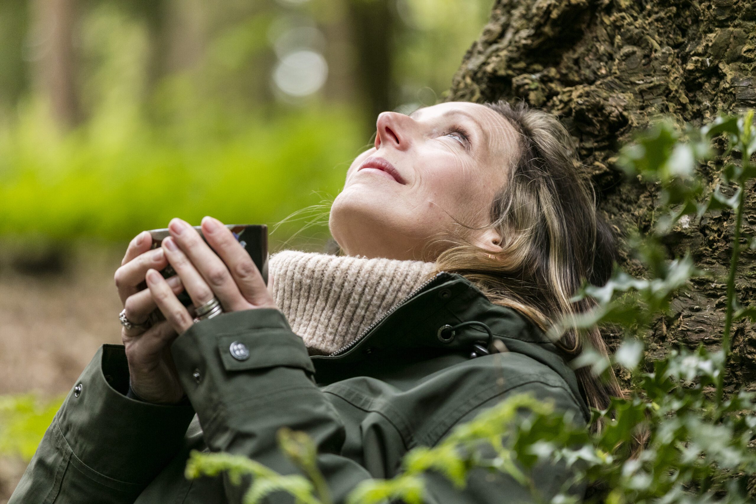 Woman drinking tea under a tree