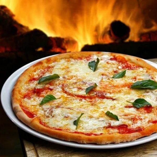 Close-up of pizza, with log fire in background.