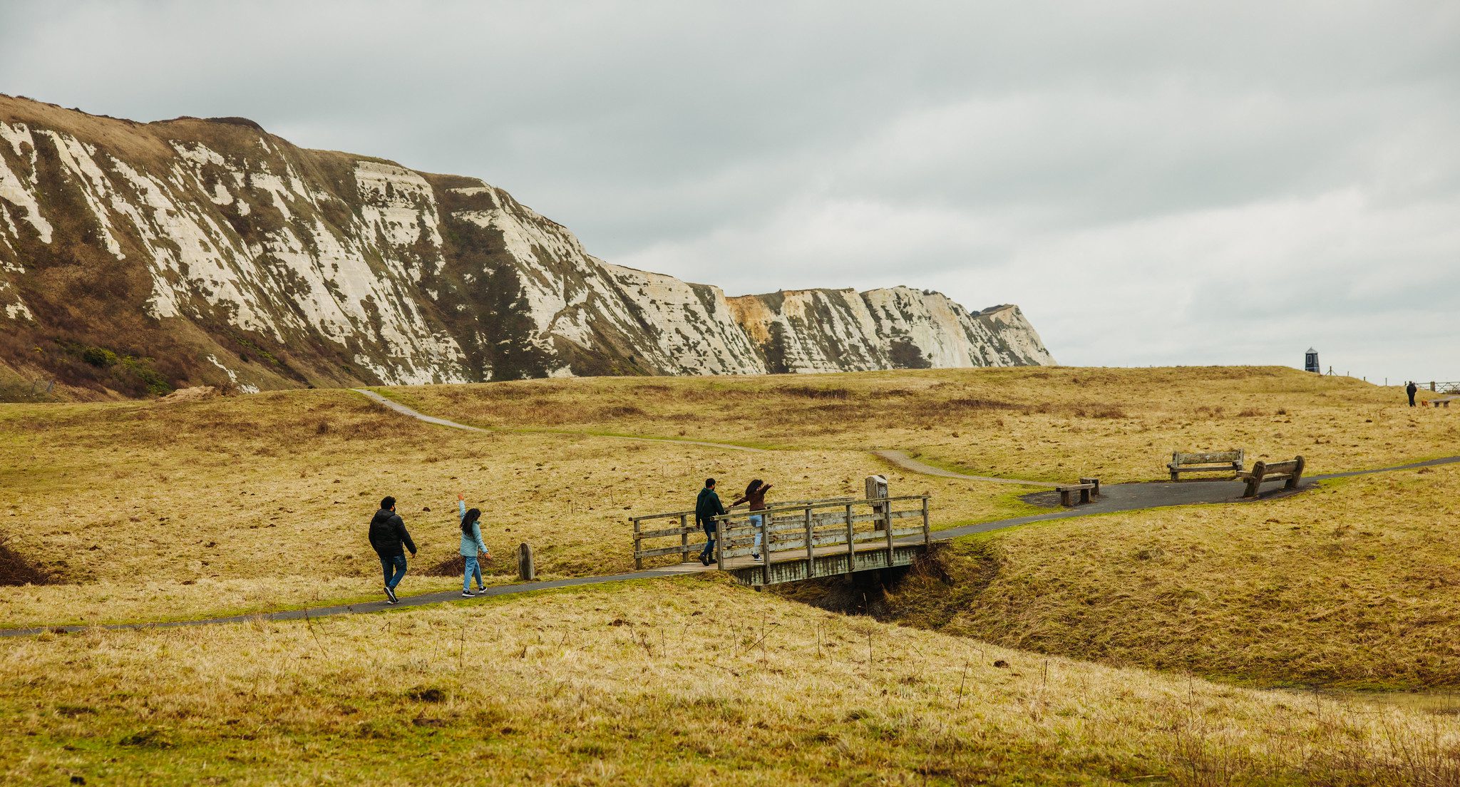 Group of people walking along a footpath beneath the White Cliffs of Dover