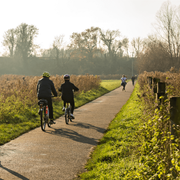 Cyclists and runner on a path, running through Great Stour Way.