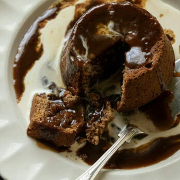 Close-up chocolate sponge pudding with cream at The Black Robin pub.