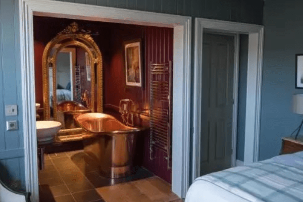 Double bedroom and bathroom with rolled top copper bath at The Marquis.