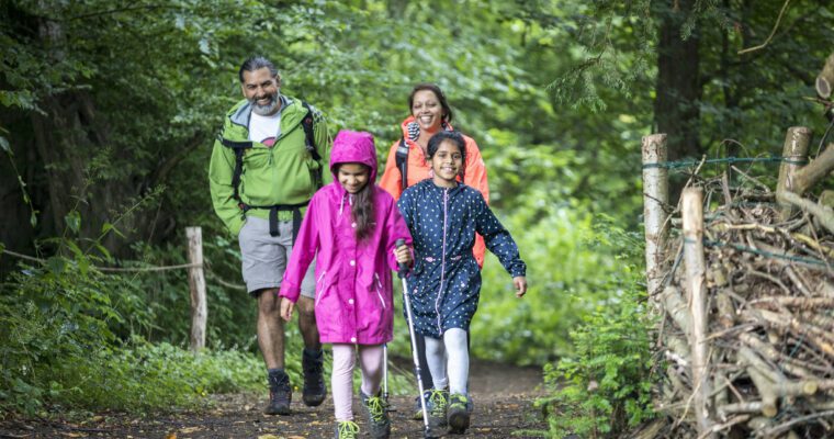 Family walking through the woods in raincoats.