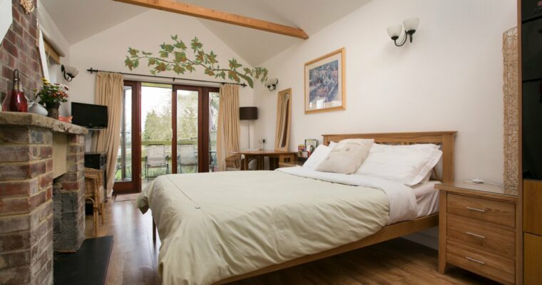 Ground level double bedroom with doors to access the garden at Iffin Farmhouse.