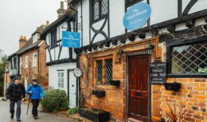 Two walkers approach tea rooms in a quaint village