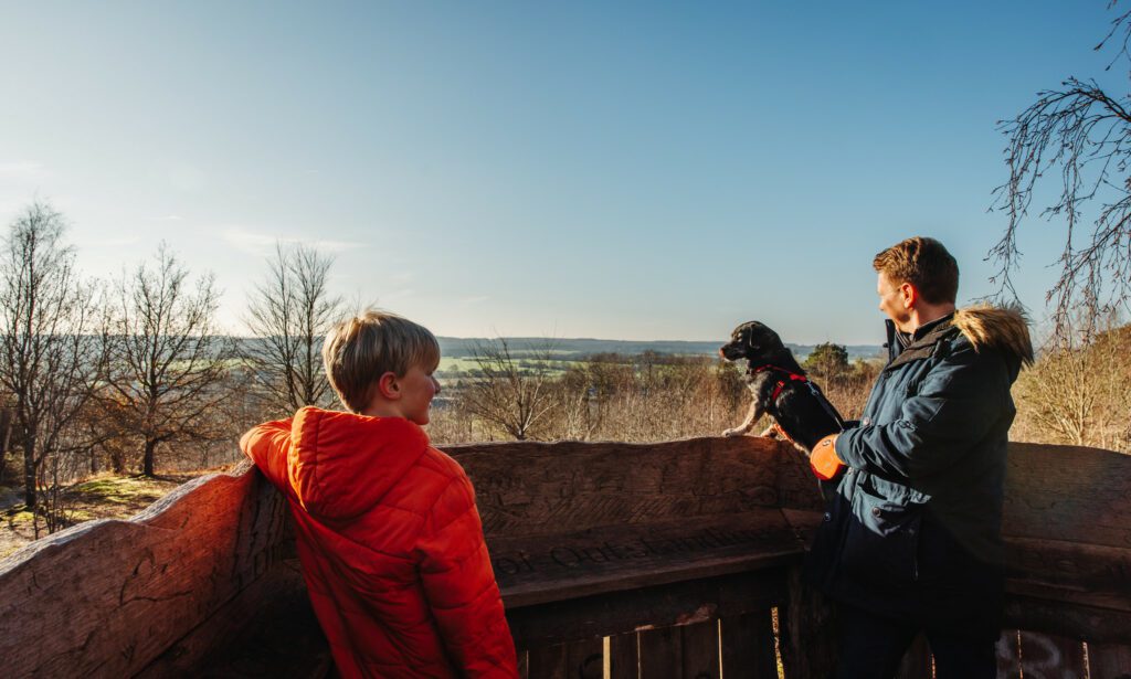 Father, son and dog look at the views from The Pulpit at Perry Wood