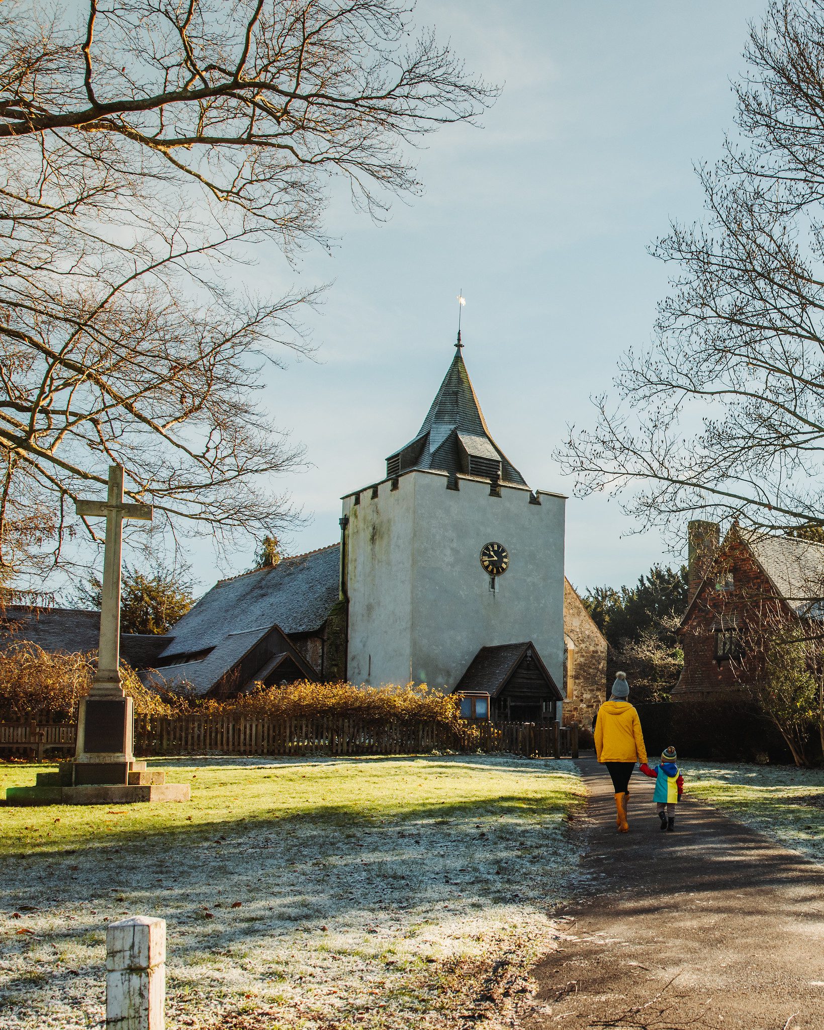 Woman and child walking along footpath to church on frosty day