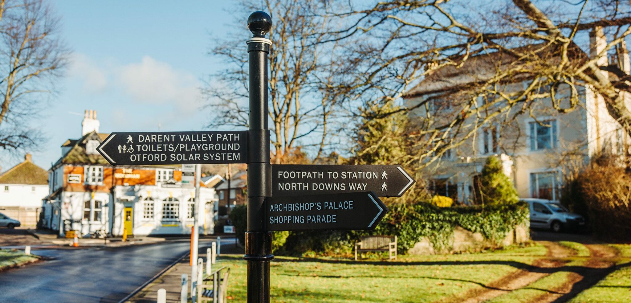 Sign post with village scene in the background