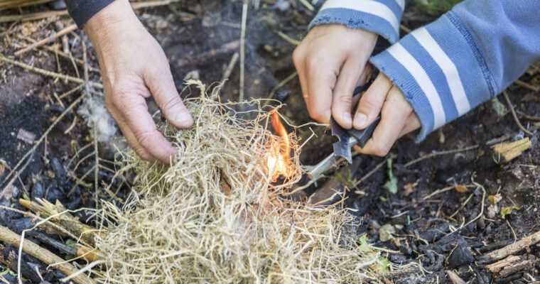 Hands lighting the campfire