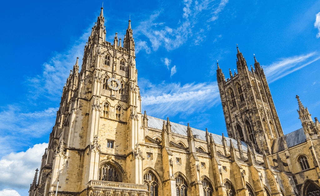 Ornate facade and spires of Canterbury Cathedral against blue sky
