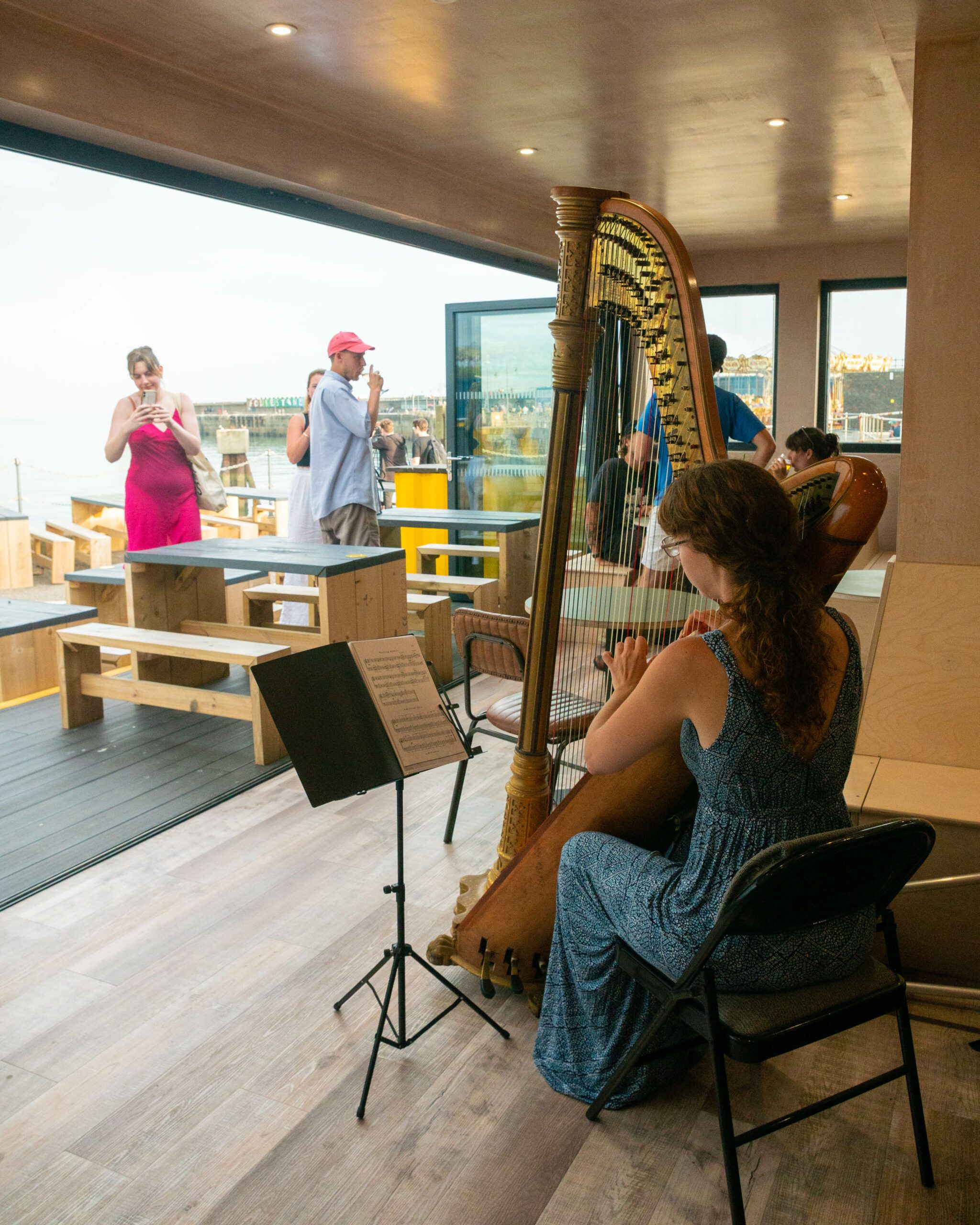 Woman playing harp in open restaurant