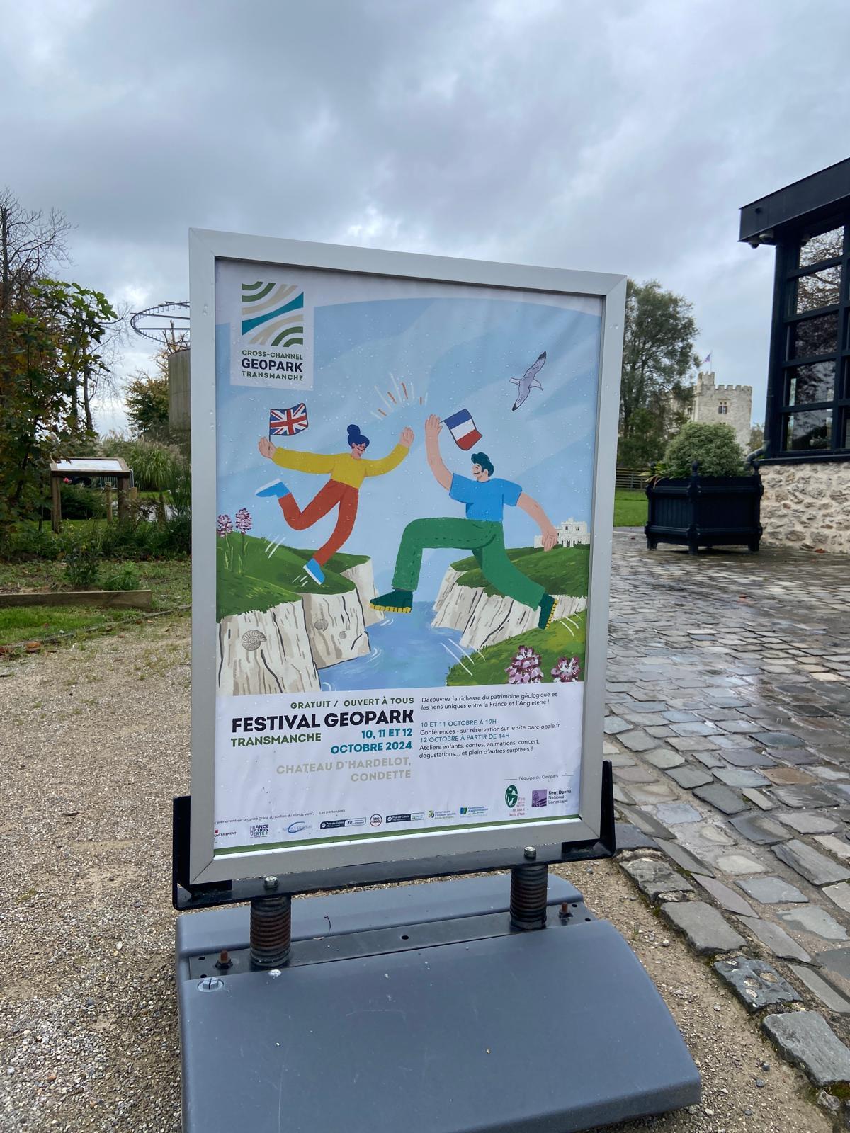 The image shows a vibrant Geopark Festival poster displayed outside Château d'Hardelot.