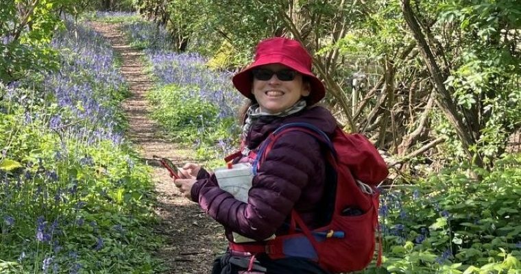 Lisa Spender walking through a bluebell wood.
