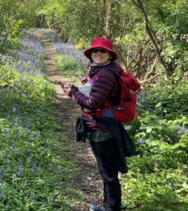 Lisa Spender, North Downs Way Ambassador, walking through a bluebell wood,
