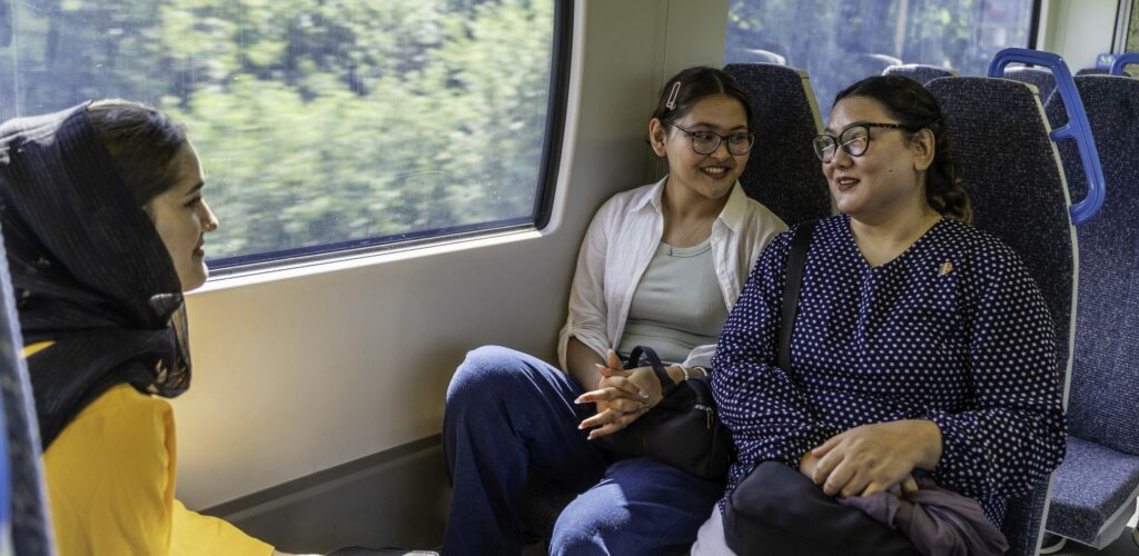 A group of women sit together on the train