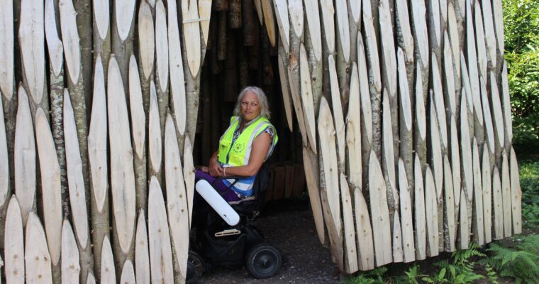 Gini Mitchell sits in a wheelchair in the Coppice Oratory sculpture on the North Downs Way.